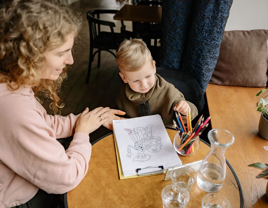 A psychologist and a child drawing together at a table