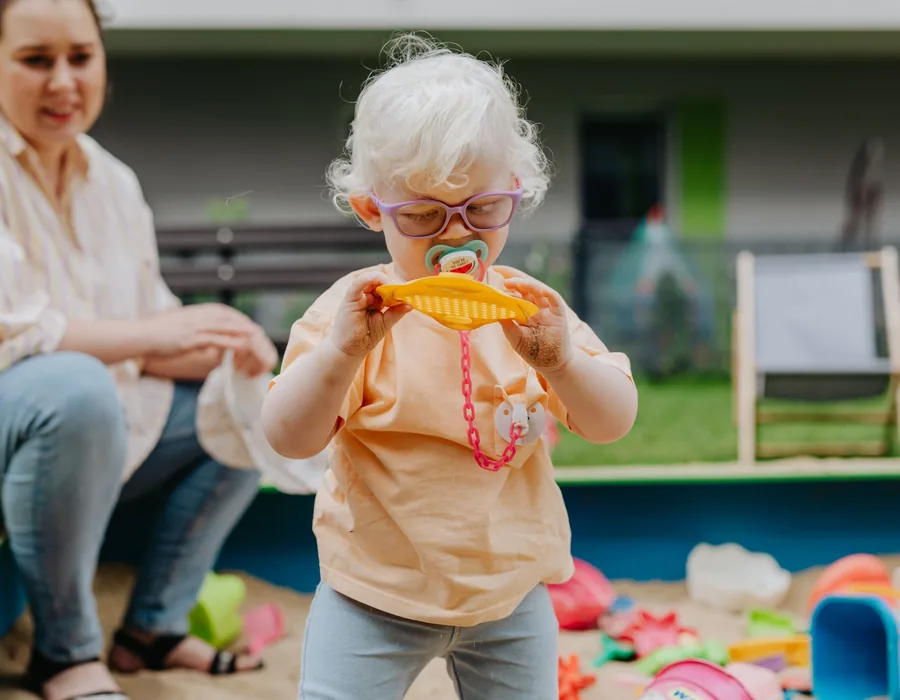 A therapist playing with a child at a therapeutic sand tray