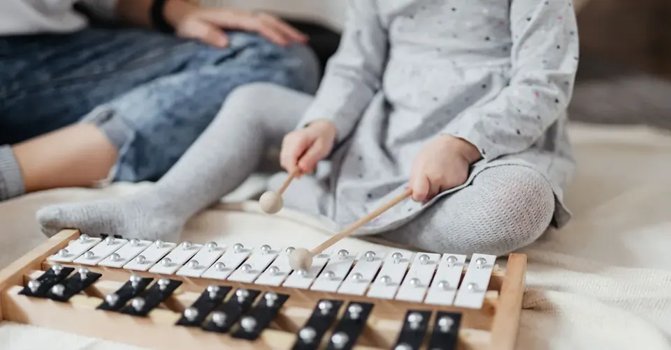 Dziewczynka gra na instrumencie podczas zajęć